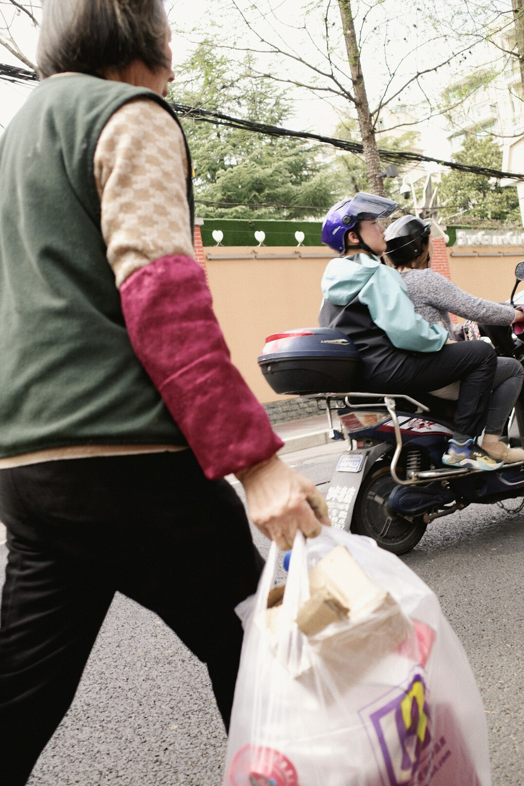 Young volunteer helping an elderly woman carry groceries
