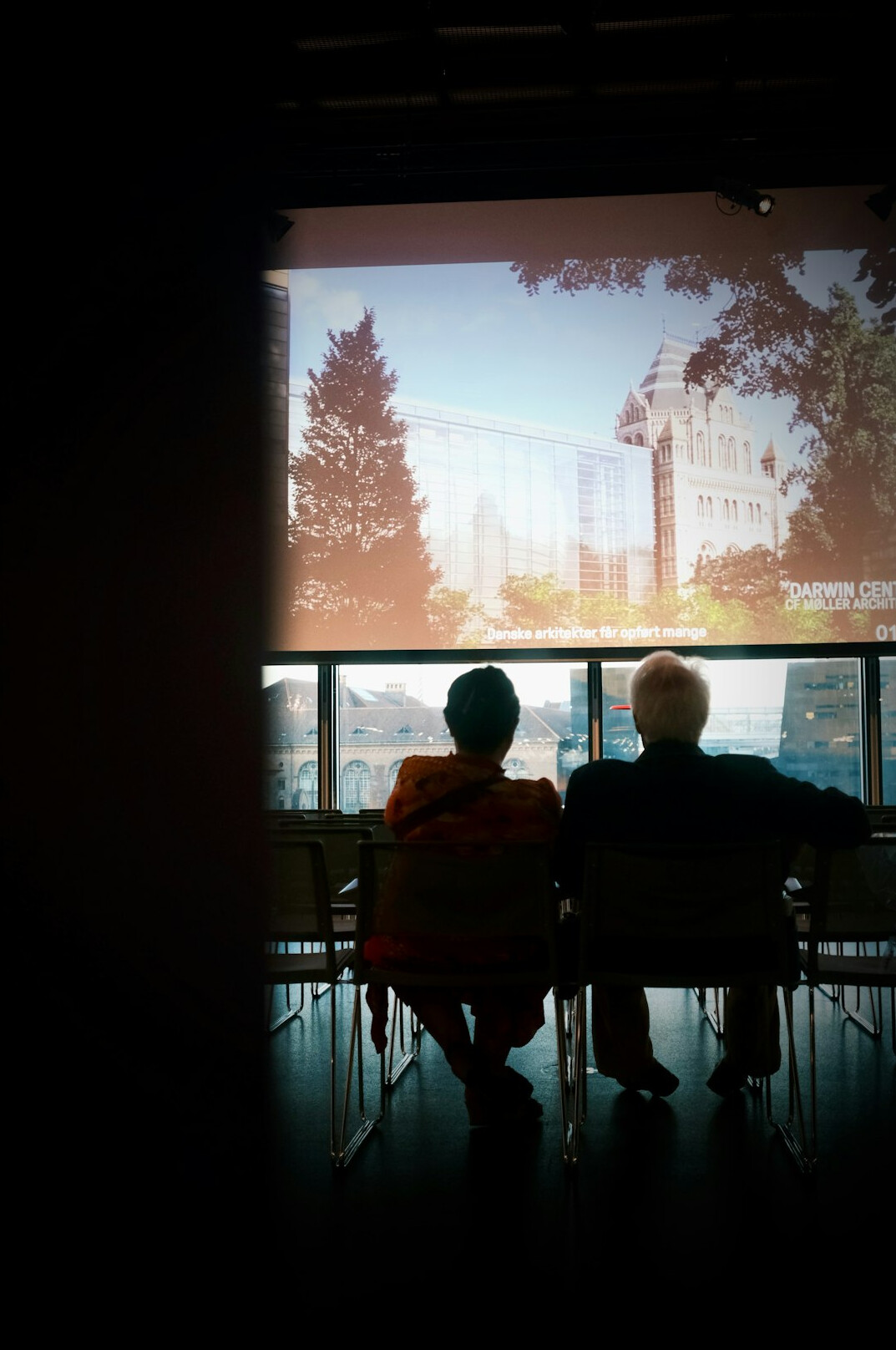 Elderly friends watching a film together in a community room